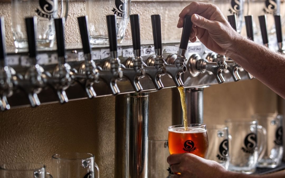 Satire Brewing Company Denver, CO- Man pouring beer into glass.
