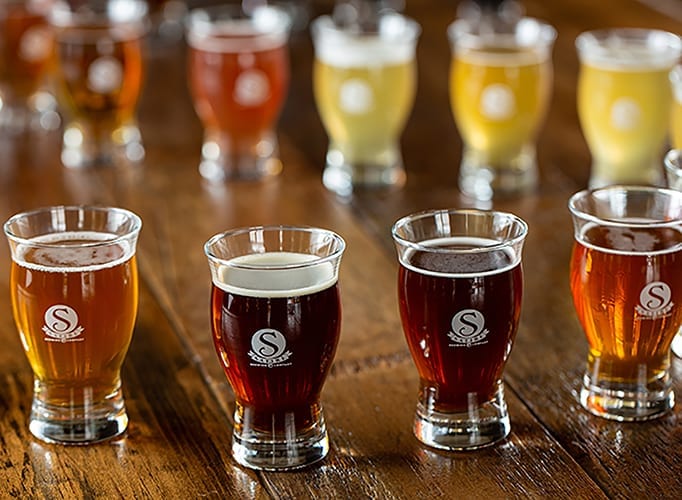 Multiple beers in glasses on counter- Satire Brewing Company