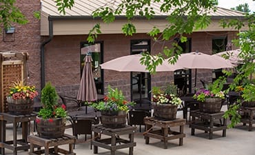 Picture of outside patio with flowers and tables- Satire Brewing Company